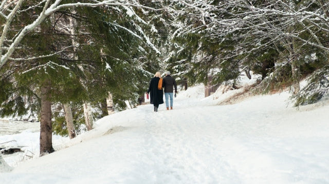 Pärchen auf einem verschneiten Weg im Wald