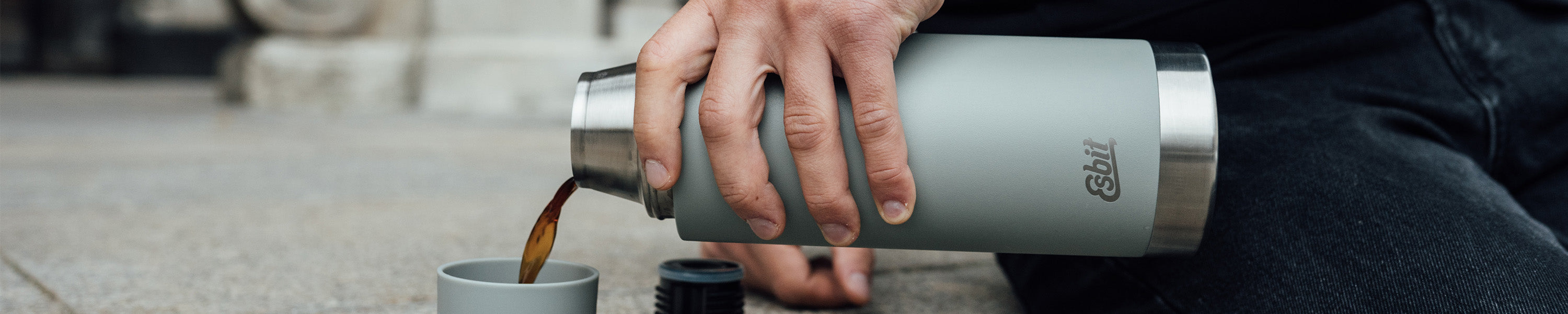 SCULPTOR Isolierflasche in Stone Grey schenkt Kaffee in ihren Trinkbecher.