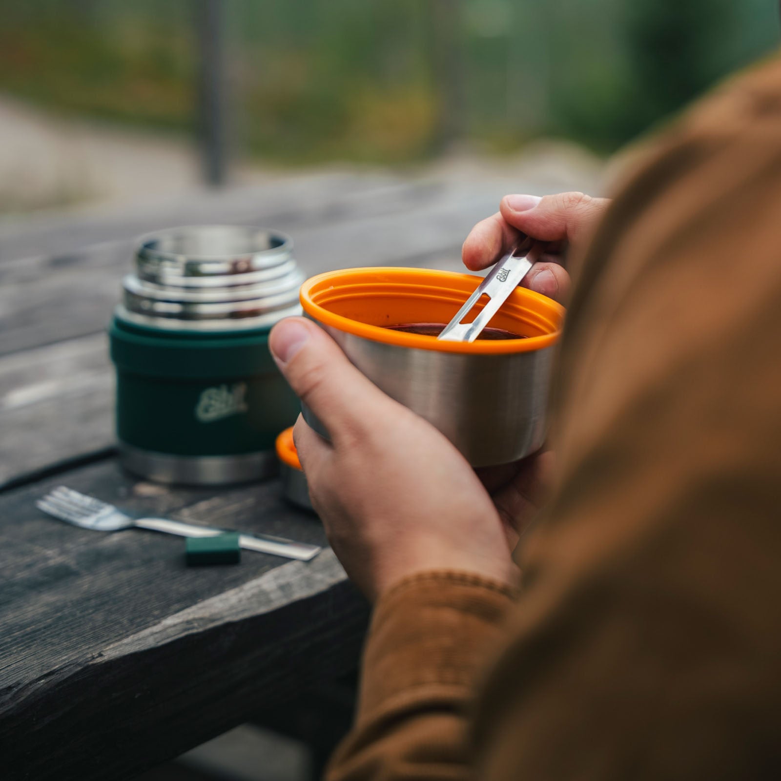 Person isst aus Esbit Food Jug in der Natur