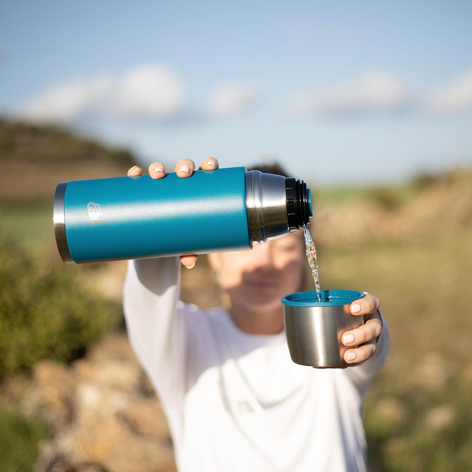 Esbit CLASSIC Isolierflasche blau 1000 ml Frau füllt Getränk in Becher
