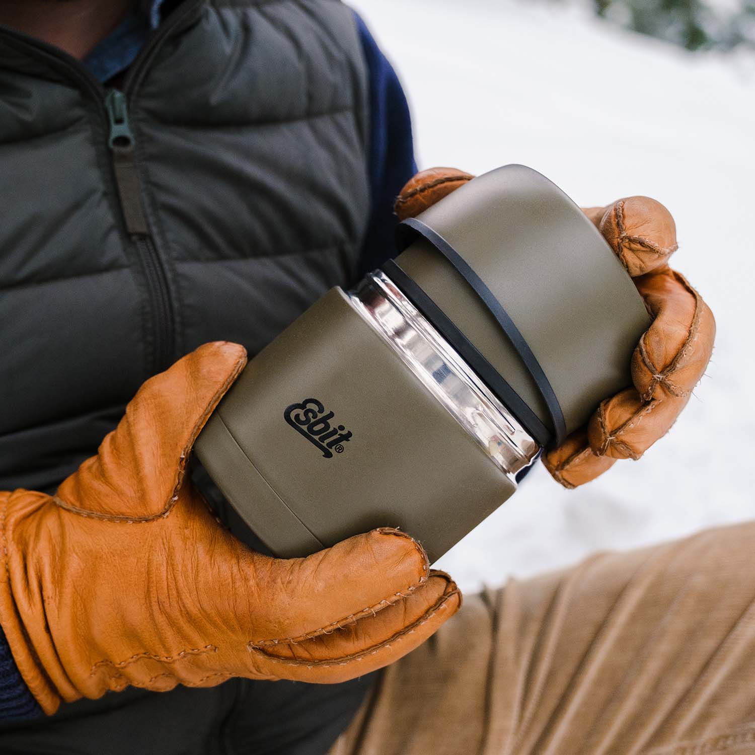 Mann mit orangenen Handschuhen öffnet den Deckel vom CLASSIC Thermobehälter in Olivgrün für 500 ml.