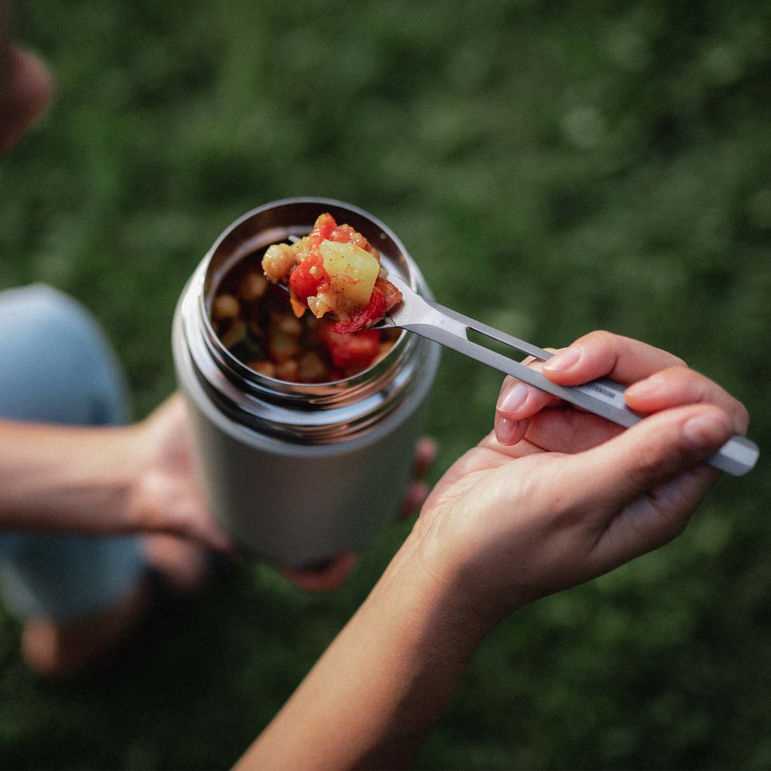 Frau isst einen Kartoffel-Salat direkt aus dem SCULPTOR Thermobehälter in Stone Grey.