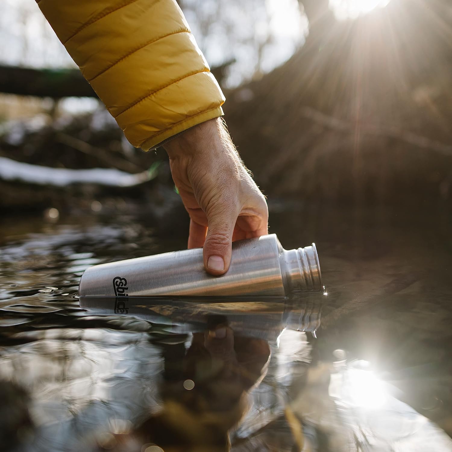 Esbit SCULPTOR Edelstahl Trinkflasche beim Auffüllen im Fluss