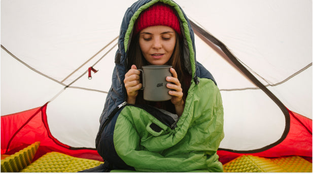 Frau im Zelt hält Esbit Titan Camping Topf in der Hand 