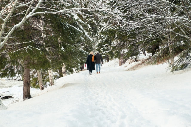 Pärchen auf einem verschneiten Weg im Wald 