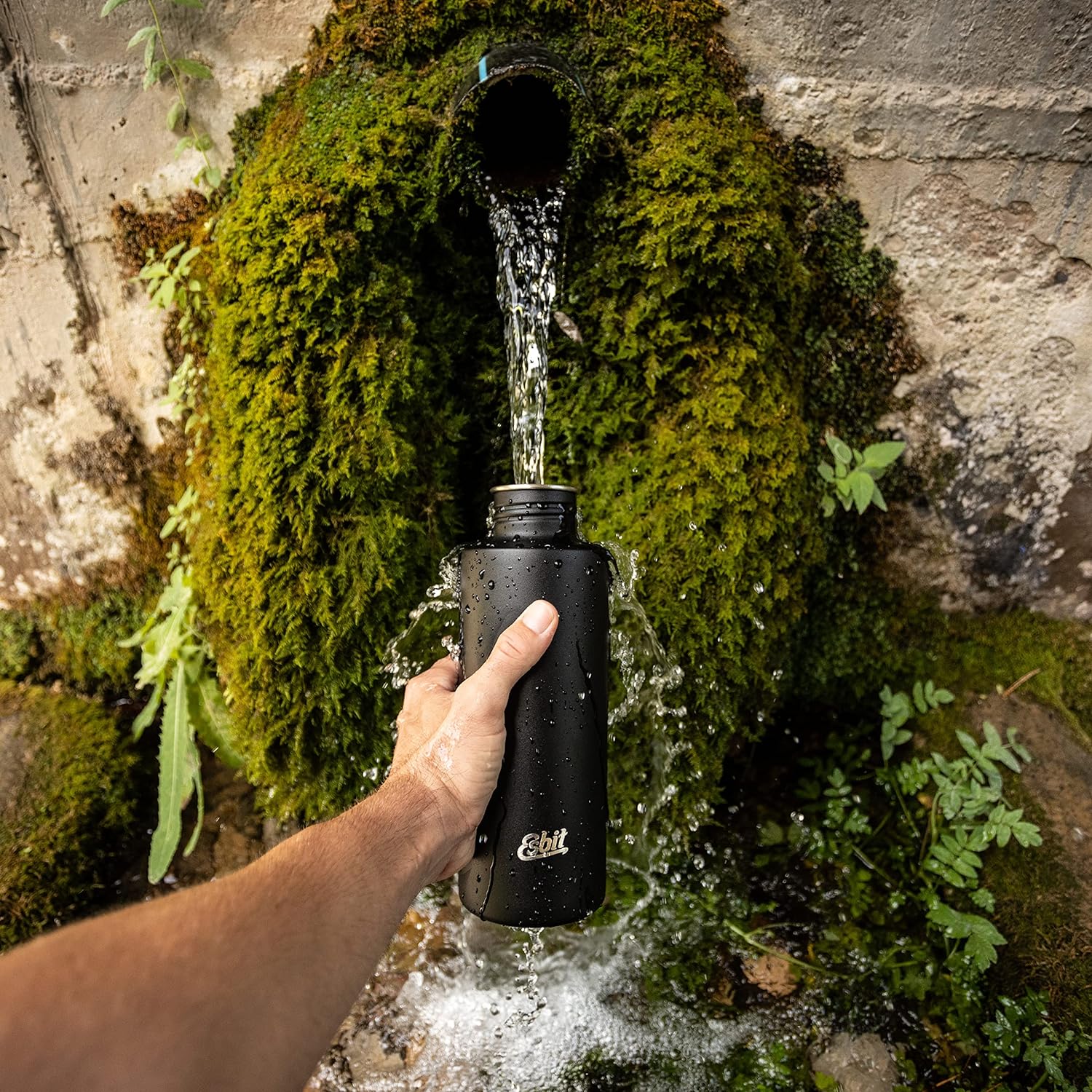 Esbit SCULPTOR Edelstahl Trinkflasche in Schwarz beim Auffüllen in der Natur 