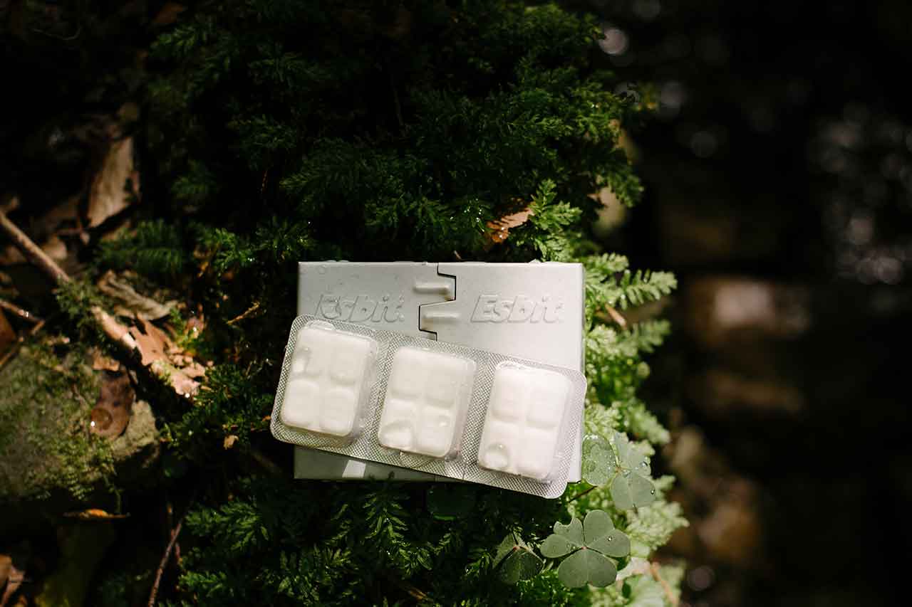 Esbit Taschenkocher klein mit 14 g Trockenbrennstofftabletten auf Waldboden